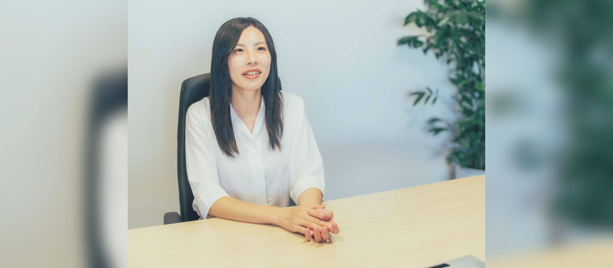 オフィス内でインタビューを受ける女性