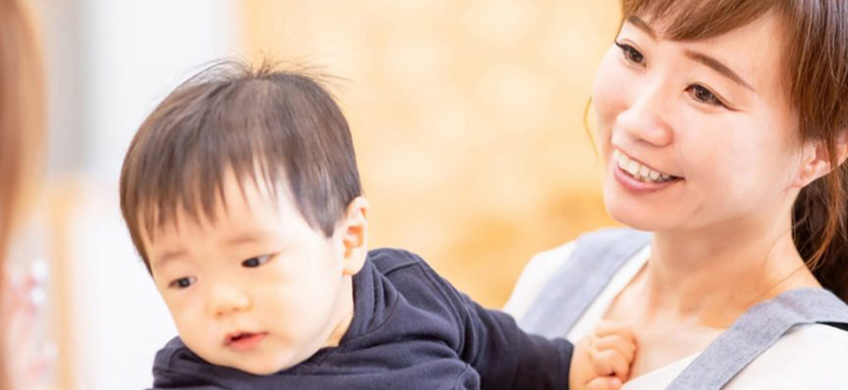 女性保育士と預かる子供の写真