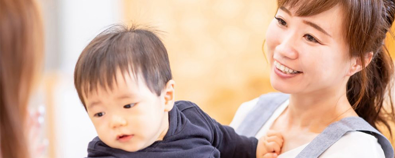 女性保育士と預かる子供の写真