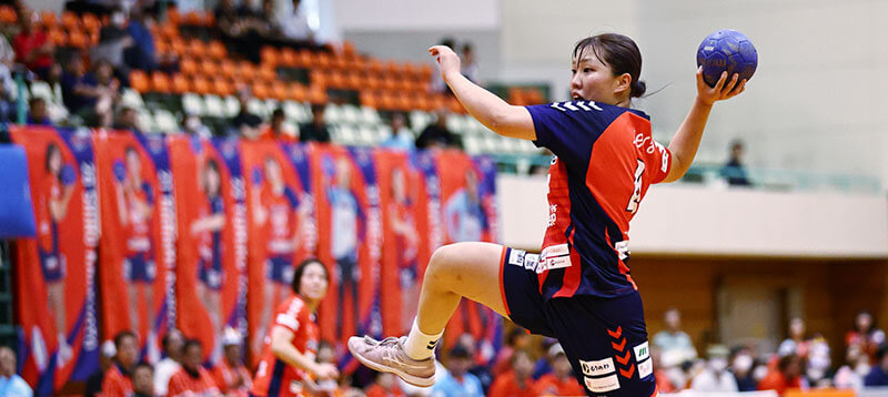 競技中に力強くシュートを放つハンドボール選手